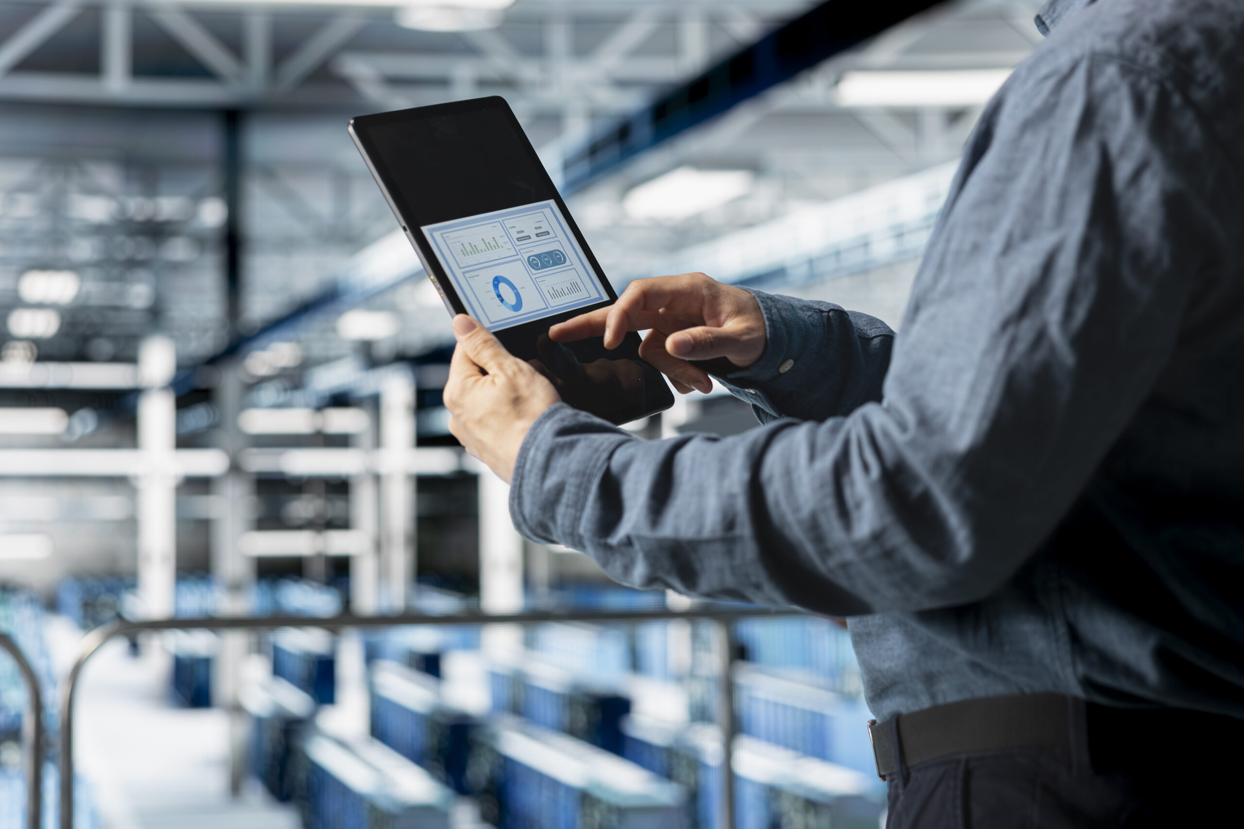 close up server room employee analyzing equipment metrics device screen scaled